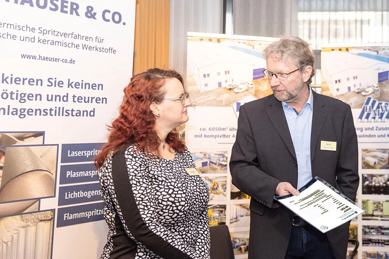 Zwei Personen im Gespräch auf dem Info-Stand der Häuser & Co GmbH