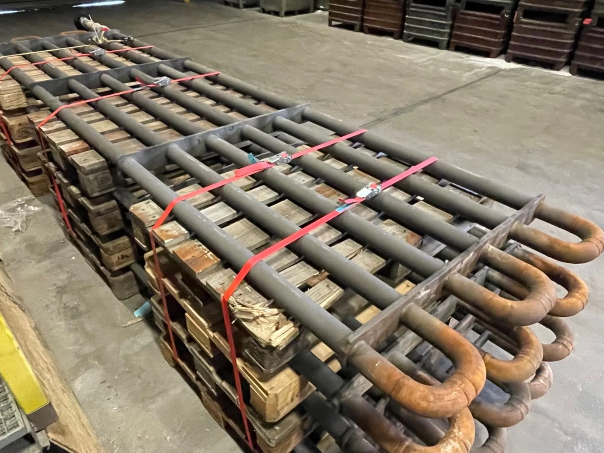 Demontierte Rohrschlangen aus der Zementindustrie auf Paletten gelagert warten auf eine Erneuerung der Beschichtung