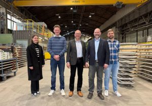 Projekt-Team KIMETRO Eine Frau und vier Männer stehen in der Produktionshalle der Fa. Häuser & Co. GmbH